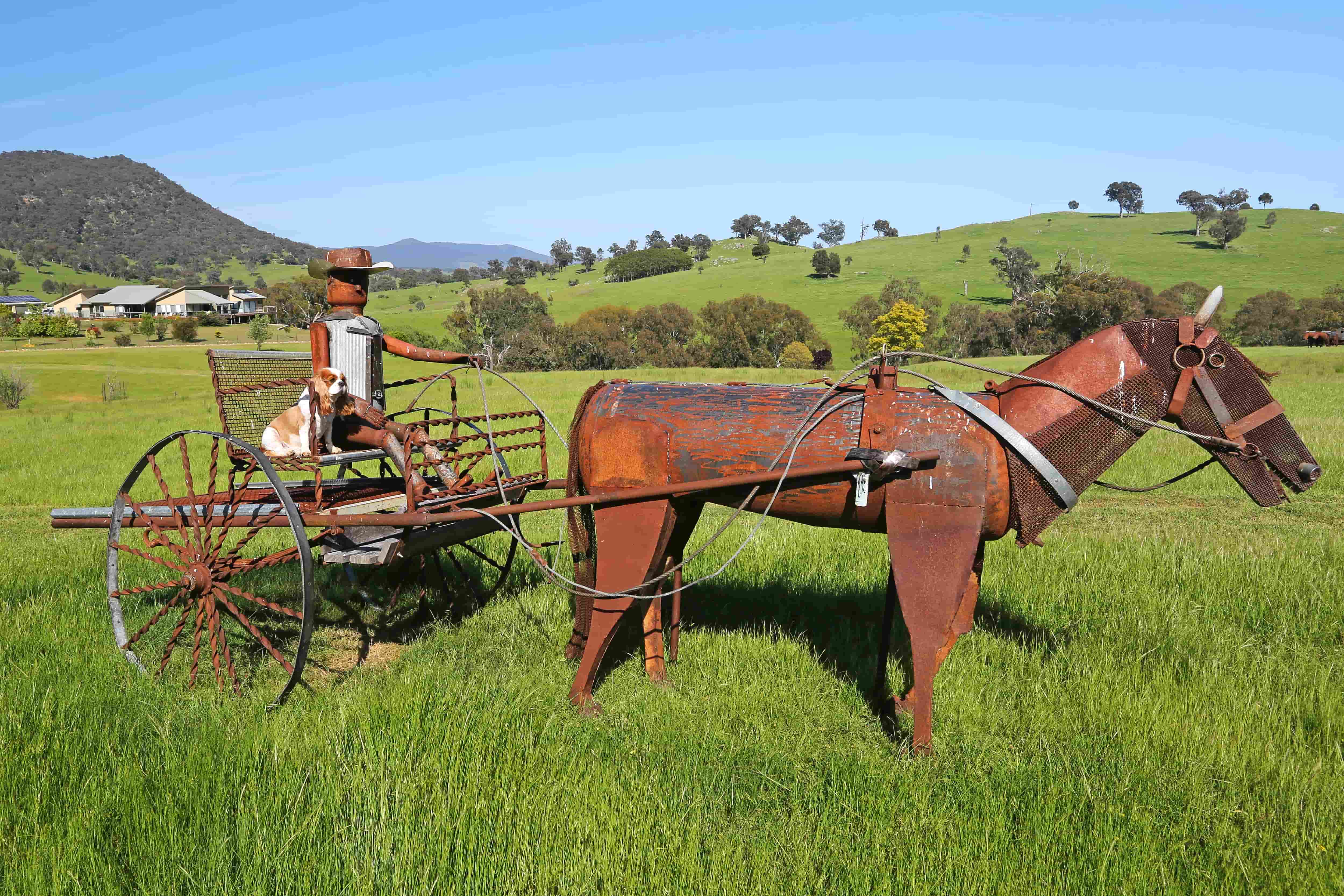 Sculpture of a cowboy and dog with the cottages in the distance