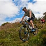 Mountain biker riding a grassy trail near Tumut