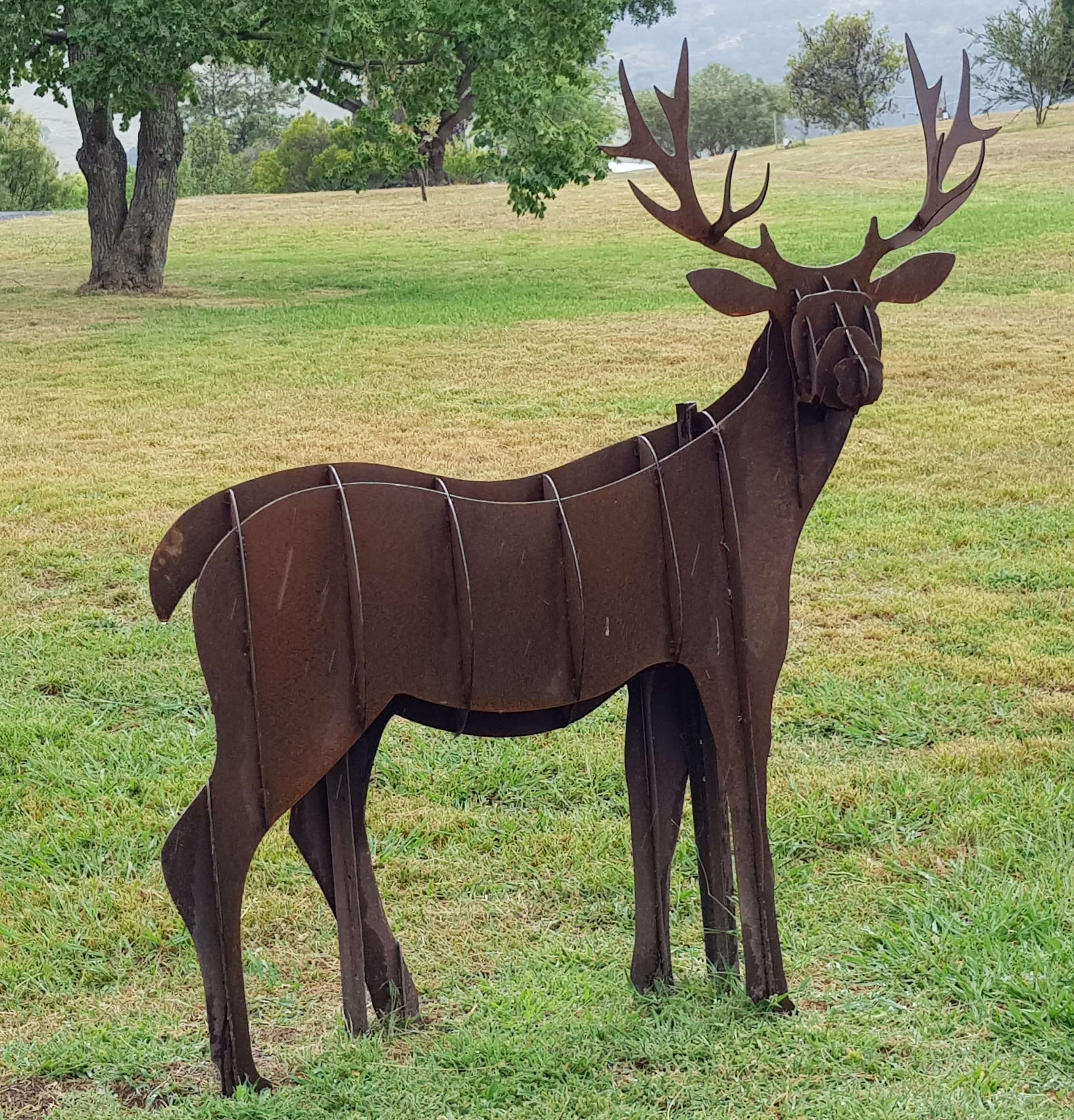Rusted steel stag sculpture standing in the paddock at Elm Cottage