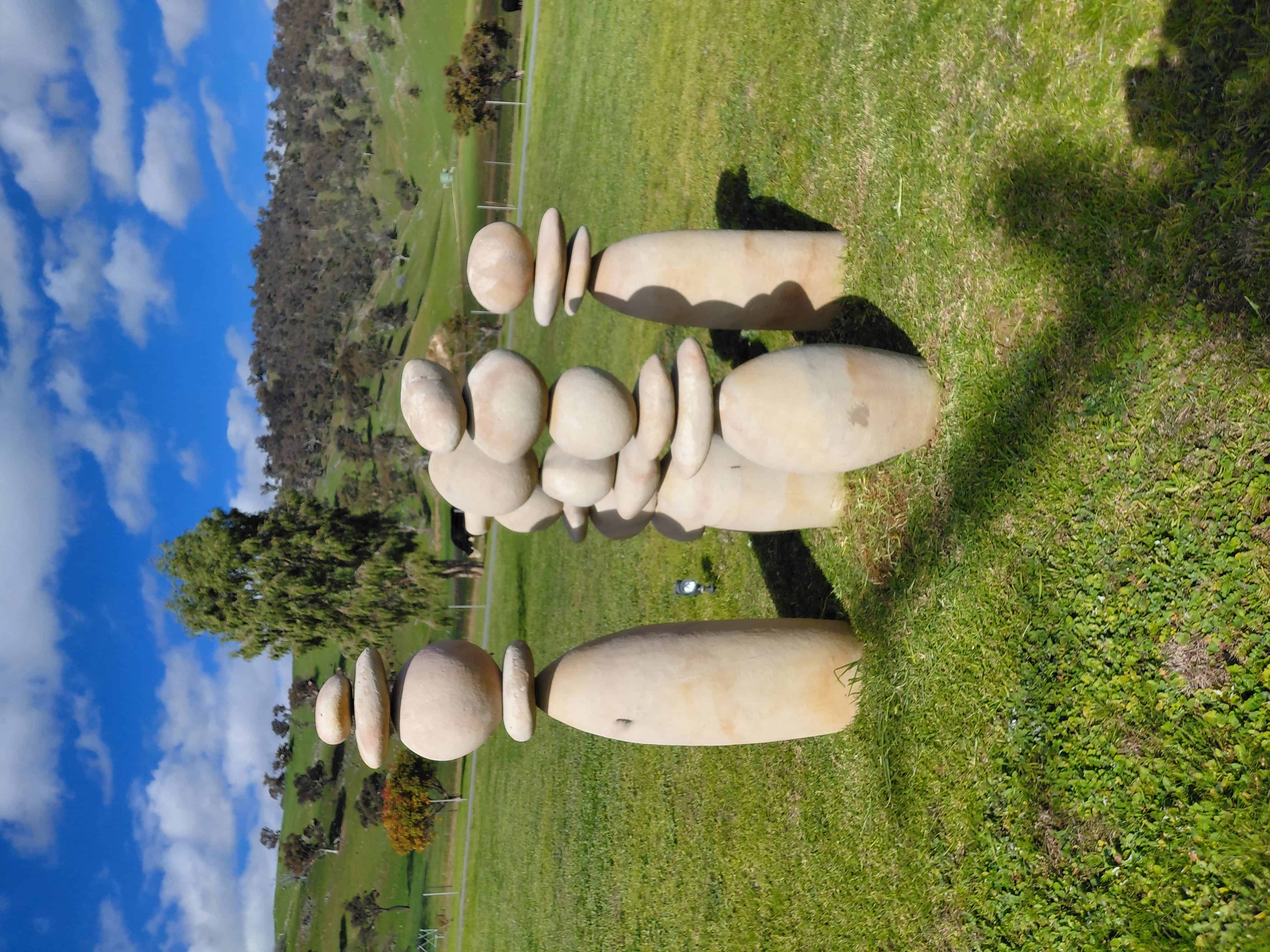 Balanced river-stone cairn sculptures on the lawn at Elm Cottage